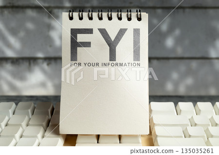 Notebook with the acronym FYI (For Your Information) is placed on an white keyboard. Ideal for business or educational content. Concept of For Your Information Notebook with the acronym FYI (For Your Information) is placed on an white keyboard. Ideal for business or educational content. Concept of For Your Information 135035261