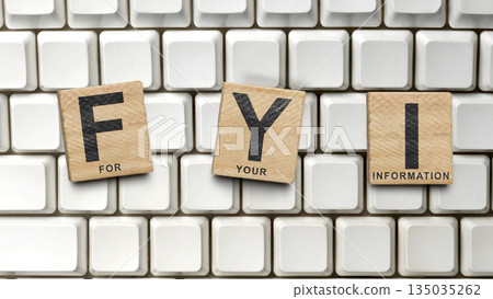 Closeup image of wooden tiles spelling out FYI (For Your Information) on a white computer keyboard. Concept of For Your Information 135035262