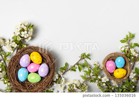 Easter colored painted eggs in bird nests and blooming spring cherry branches on gray background in shape of frame with space for text and greetings. Easter and spring concept. Spring background Easter colored painted eggs in bird nests and blooming spring cherry branches on gray background in shape of frame with space for text and greetings. Easter and spring concept. Spring background 135036016