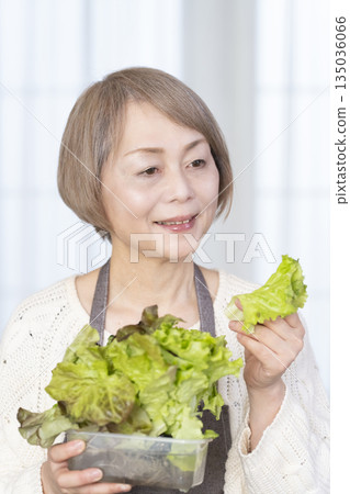 Senior woman enjoying kitchen gardening Senior woman enjoying kitchen gardening 135036066