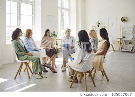 Women talking in a support circle during collaborative team training session 135037067