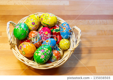 Basket with Easter eggs on wooden table 135038503