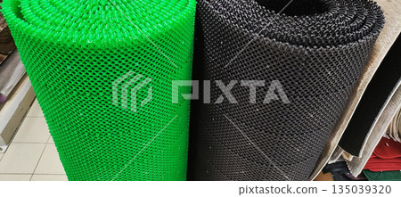 Rolled-up plastic mats vibrant green dark grey textured surface display retail store flooring solution anti-slip material home improvement product shower mat bath mat entryway mat 135039320