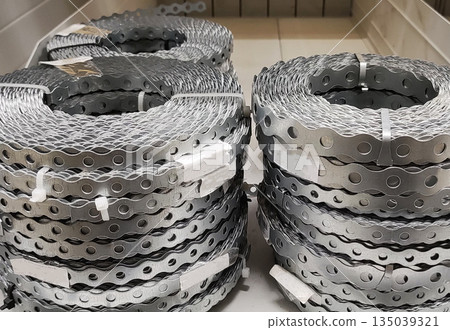 Metal strapping rolls storage construction material perforated wavy edge several units on display shelf industrial supply hardware store Metal strapping rolls storage construction material perforated wavy edge several units on display shelf industrial supply hardware store 135039321