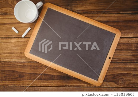 Flat design showing wood-frame chalkboard on wood-grain tabletop with chalk sticks, ceramic mug Flat design showing wood-frame chalkboard on wood-grain tabletop with chalk sticks, ceramic mug 135039605