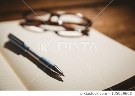 Eyeglasses and pen on book Eyeglasses and pen on book 135039668