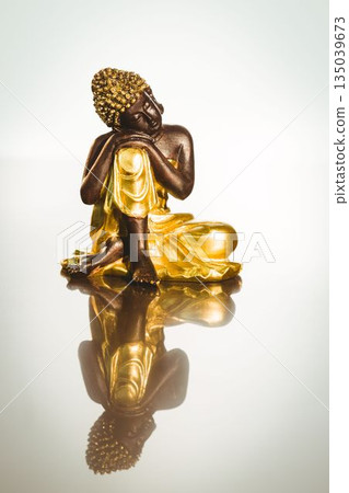 Buddha statue with reflection on table Buddha statue with reflection on table 135039673