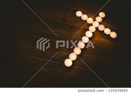 Candles in shape of cross on table Candles in shape of cross on table 135039685