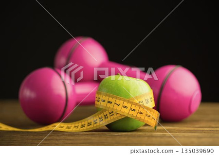 Pink dumbbells with green apple and measuring tape Pink dumbbells with green apple and measuring tape 135039690
