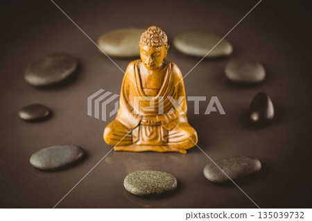 Buddha sculpture surrounded by pebbles Buddha sculpture surrounded by pebbles 135039732