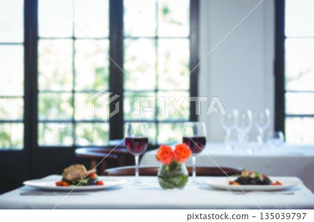 Lamb chop and wineglasses with roses on table Lamb chop and wineglasses with roses on table 135039797