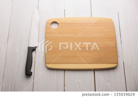 Kitchen knife and chopping board on wooden floor Kitchen knife and chopping board on wooden floor 135039829