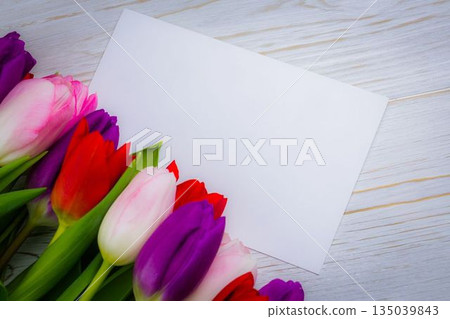 Displaying flat white card diagonally on wooden tabletop with vibrant tulip bouquet, copy space Displaying flat white card diagonally on wooden tabletop with vibrant tulip bouquet, copy space 135039843