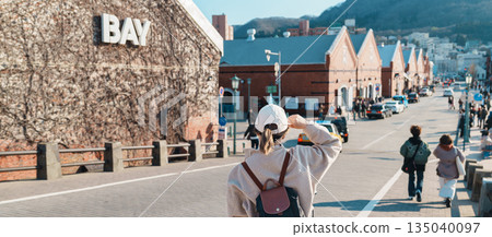 Woman tourist Visiting in Hakodate, happy Traveler sightseeing Kanemori Red Brick Warehouse in spring season. landmark and popular for attractions in Hokkaido, Japan. Travel and Vacation concept Woman tourist Visiting in Hakodate, happy Traveler sightseeing Kanemori Red Brick Warehouse in spring season. landmark and popular for attractions in Hokkaido, Japan. Travel and Vacation concept 135040097