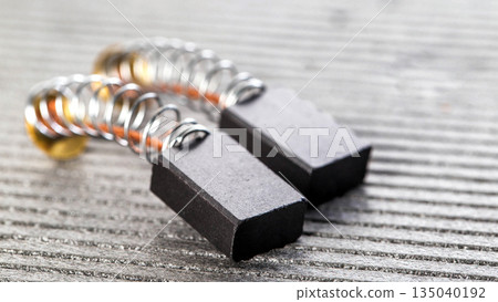 New brushes for replacement in an electric motor on a gray background, close-up, industry 135040192