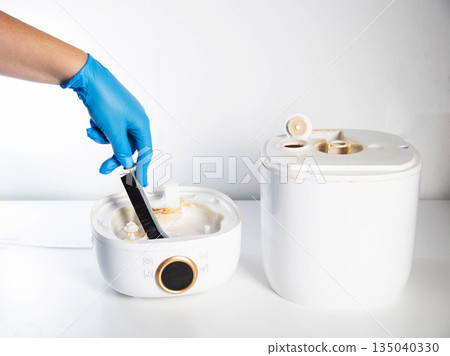 Cleaning the humidifier from scale, rust and unpleasant odors with a special brush and chemical agent. Service, close-up. Copy space for text 135040330