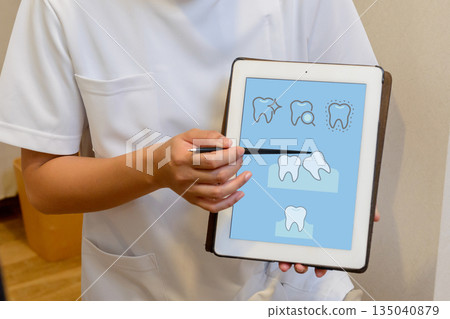 A scene where a dentist explains the condition of teeth using a tablet A scene where a dentist explains the condition of teeth using a tablet 135040879