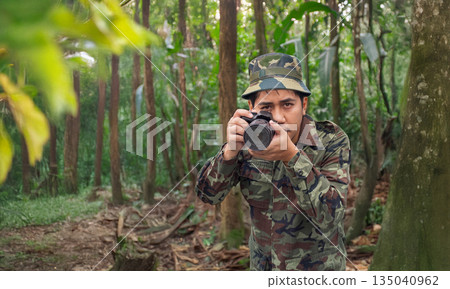A man in a military uniform is capturing the beauty of nature with a DSLR camera. A man in a military uniform is capturing the beauty of nature with a DSLR camera. 135040962