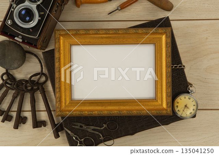 Photo frame, clock, keys, camera on wooden table Photo frame, clock, keys, camera on wooden table 135041250