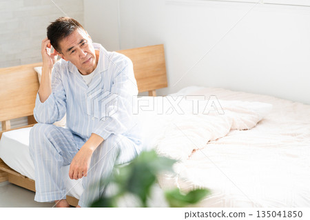 A man who wakes up and worries on his bed A man who wakes up and worries on his bed 135041850