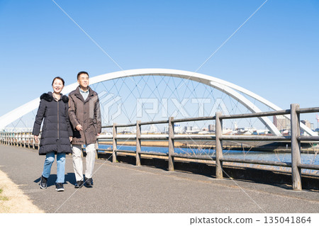 A middle-aged couple walking along a promenade 135041864