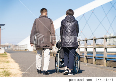 父母和孩子推著輪椅四處走動 父母和孩子推著輪椅四處走動 135041871