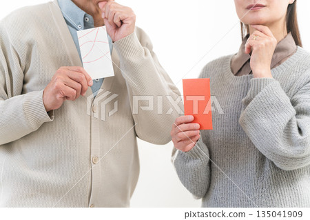 A middle-aged couple discussing the price of New Year's gifts A middle-aged couple discussing the price of New Year's gifts 135041909