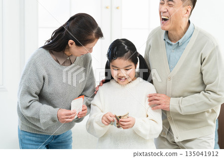 A girl receiving New Year's money from her grandfather and grandmother A girl receiving New Year's money from her grandfather and grandmother 135041912