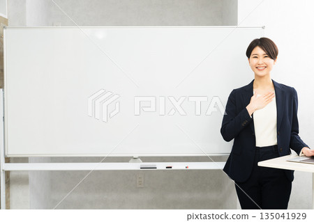 一位女性研討會講師站在白板前 135041929
