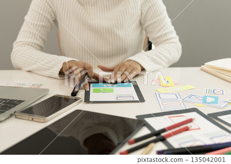 Creative web designer planning UI application and developing digital template 135042001