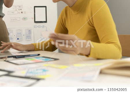 Creative web designer planning UI application and developing digital template 135042005