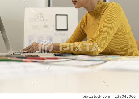 Creative web designer planning UI application and developing digital template 135042006