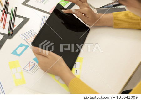 Creative web designer planning UI application and developing digital template 135042009