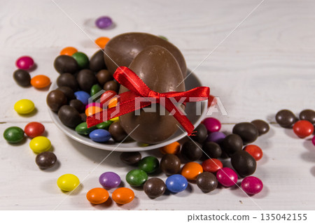 Easter composition with chocolate eggs on white wooden background Easter composition with chocolate eggs on white wooden background 135042155