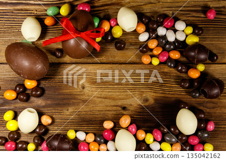 Easter composition with chocolate eggs on wooden background Easter composition with chocolate eggs on wooden background 135042162