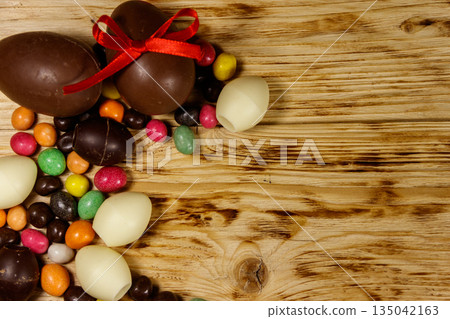 Easter composition with chocolate eggs on wooden background Easter composition with chocolate eggs on wooden background 135042163