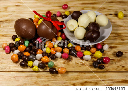Easter composition with chocolate eggs on wooden background Easter composition with chocolate eggs on wooden background 135042165