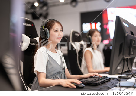 Young woman enjoying games at an e-sports tournament Young woman enjoying games at an e-sports tournament 135043547