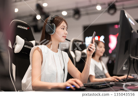 Young woman enjoying games at an e-sports tournament Young woman enjoying games at an e-sports tournament 135043556
