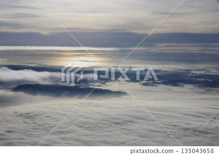 A pale white sea of clouds seen from inside the plane 135043658