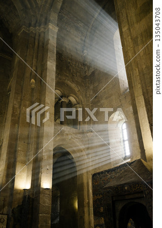Light Beams Streaming Through Window in Ancient Stone Cathedral Interior Light Beams Streaming Through Window in Ancient Stone Cathedral Interior 135043708