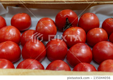 Fresh Red Tomatoes in Cardboard Boxes for Market Sale and Produce Display Fresh Red Tomatoes in Cardboard Boxes for Market Sale and Produce Display 135044056