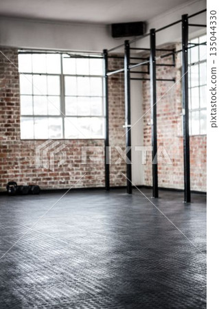 Black steel pull-up rig is standing in flat design brick gym with dumbbells and rubber mats 135044330