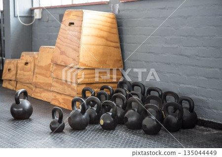 Group of kettlebells is filling flat design gym corner with rubber mat, showing stacked plyo boxes Group of kettlebells is filling flat design gym corner with rubber mat, showing stacked plyo boxes 135044449