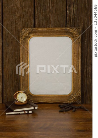 Photo frame, clock and books on table 135044569