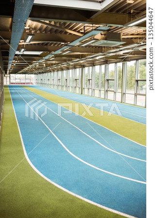 Empty blue running track in indoor stadium Empty blue running track in indoor stadium 135044647