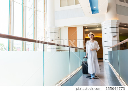 A woman walking down an airport corridor A woman walking down an airport corridor 135044773