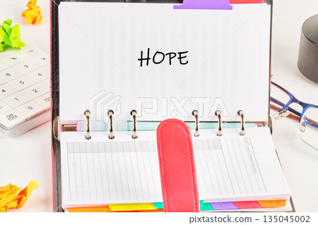 An open journal displays the word HOPE written in bold letters An open journal displays the word HOPE written in bold letters 135045002