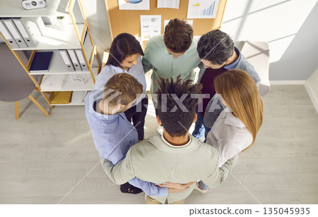 Team of young multiracial business men and women standing in a circle in the office Team of young multiracial business men and women standing in a circle in the office 135045935