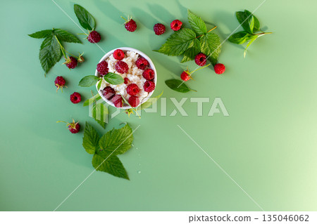Summer cottage cheese with raspberries and green leaves on top Summer cottage cheese with raspberries and green leaves on top 135046062